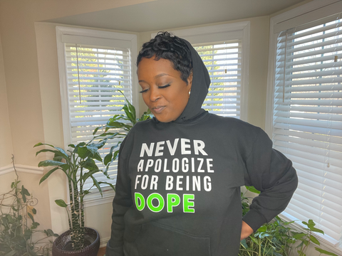 Black Hooded Sweatshirt with Matching Drawstrings and Front Pouch Pocket with the words Never Apologize For being Dope on the front. .  Cotton Polyester Blend Available in S, M, L, XL